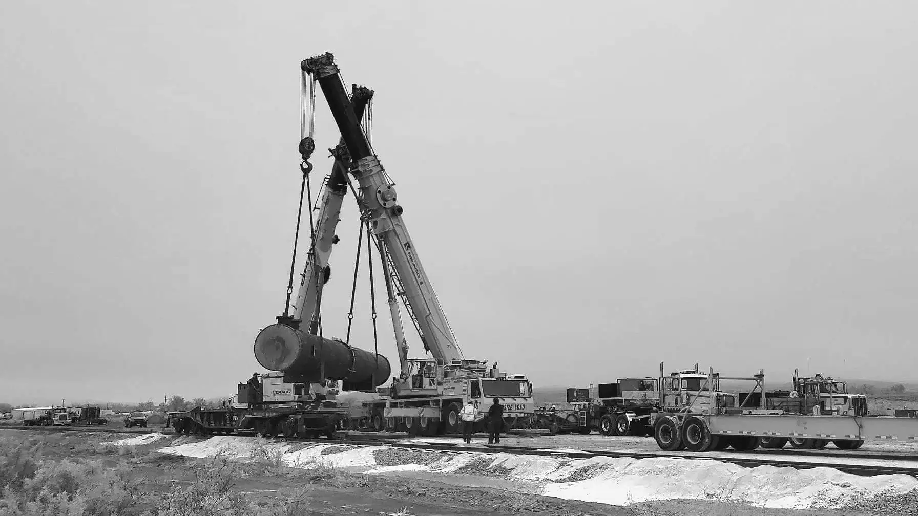 A large crane is lifting a pipe.